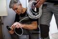 Fix it. Cropped shot of aged electrician, repairman in uniform working, examining cable, checking voltage in fuse box