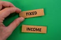 Fixed income words written on torn paper pieces with green background Royalty Free Stock Photo