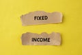 Fixed income words written on torn paper pieces with yellow background Royalty Free Stock Photo