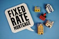 Fixed-Rate Mortgage text with house models on blue background Royalty Free Stock Photo