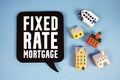 Fixed-Rate Mortgage text with house models on blue background Royalty Free Stock Photo