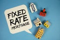 Fixed-Rate Mortgage text with house models on blue background Royalty Free Stock Photo