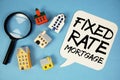 Fixed Rate Mortgage text with house models on blue background Royalty Free Stock Photo
