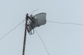 A fixed wireless internet antenna mounted on the roof of a house. Wireless broadband service at a rural area. Overcast weather