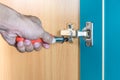 Fixing cabinet door hinge using a screwdriver Royalty Free Stock Photo