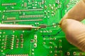 Fixing the chip with a soldering iron using tin solder Royalty Free Stock Photo