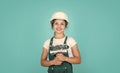 fixing everything. kid wear helmet on construction site. teen girl plasterer with tool spatula. child on repairing work Royalty Free Stock Photo
