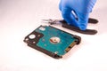 Fixing a hard disk drive with one hand with gloves and a special tweezers Royalty Free Stock Photo