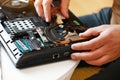 Fixing laptop. Repairman holds cooling fan and repairs from overheating. Disassembling computer, replacement, clean dust