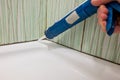 Fixing old mold destroy join lines in bathroom with caulking gun.
