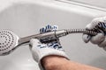 Fixing the shower hose and mixer in the bathroom. Male hands of plumber doing house maintenance