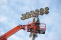 Fixing stadium light high up in the clouds Royalty Free Stock Photo