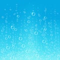 Fizzing air bubbles in water on blue background.