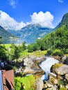 Fjord in Norway. Waterfall, mountains and village.