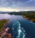 Fjord summer dusk landscape with flowing tidal current water. View from bridge (Norway