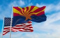 flag of Arizona state, Usa in front of official Flag of US at cloudy sky background. United states of America patriotic concept. Royalty Free Stock Photo