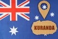 The flag of Australia has a geolocation symbol and a sign with the inscription - Kuranda