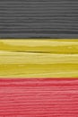 The flag of Belgium on dry cracked wooden surface. It seems to flutter in the wind. Faded paint. Vertical background or backdrop Royalty Free Stock Photo