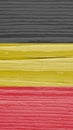 The flag of Belgium on dry cracked wooden surface. It seems to flutter in the wind. Faded paint. Vertical mobile phone wallpaper Royalty Free Stock Photo