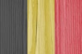 The flag of Belgium on dry wooden surface, cracked with age. Pale faded paint. Background, wallpaper or backdrop with Belgian Royalty Free Stock Photo