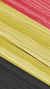 The flag of Belgium on dry wooden surface, cracked with age. Pale faded paint. Vertical mobile phone wallpaper or background with Royalty Free Stock Photo