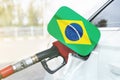 Flag of Brazil on the car`s fuel filler flap with gas pump nozzle in the tank Royalty Free Stock Photo