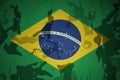 flag of brazil on the khaki texture . military concept