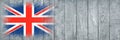 Flag of Britain. Flag is painted on a gray wooden plank surface. Wooden background. Plywood surface. Copy space. Textured Royalty Free Stock Photo