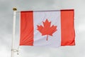 Canadian flag in the sky with white clouds