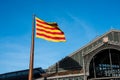 Flag of Catalonia. Senyera. Red and yellow striped flag and on clean blue sky background. Flag waving in the wind in sunny day.