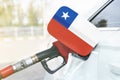 Flag of Chile on the car`s fuel filler flap with gas pump nozzle in the tank Royalty Free Stock Photo