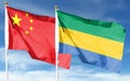 Flag of China and Republic of Gabon on cloudy sky. Royalty Free Stock Photo
