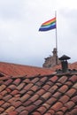 flag of cusco tied to a cross. Rainbow flag on top of Church