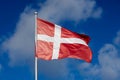 Flag of Denmark against a blue sky. Royalty Free Stock Photo