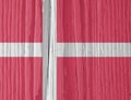 The flag of Denmark on a dry wooden surface, cracked with age. Light pale faded paint. Background, wallpaper or backdrop with Royalty Free Stock Photo