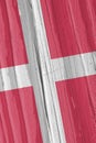 The flag of Denmark on a dry wooden surface, cracked with age. Light pale faded paint. Vertical background, wallpaper or backdrop Royalty Free Stock Photo