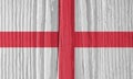 The flag of England on a dry wooden surface, cracked with age. It seems to flutter in the wind. Background, wallpaper or backdrop Royalty Free Stock Photo