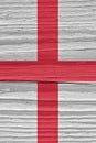 The flag of England on a dry wooden surface, cracked with age. It seems to flutter in the wind. Vertical background or backdrop Royalty Free Stock Photo