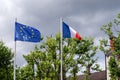 Flag of EU, european union and France, tricolor red white blue colors, fluttering, waving on flagpole in wind against sky and Royalty Free Stock Photo