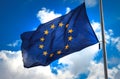 Flag of the European Union against a blue cloudy sky. Royalty Free Stock Photo