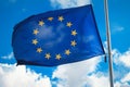 Flag of the European Union against a blue cloudy sky. Royalty Free Stock Photo