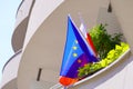 The flag of European Union is blue with stars and flag of Poland is red with white. Hanging flags on balconies of apartment