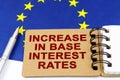 On the flag of the European Union lies a pen and a notepad with the inscription - increase in base interest rates Royalty Free Stock Photo