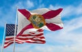 flag of Florida state, Usa in front of official Flag of US at cloudy sky background. United states of America patriotic concept.
