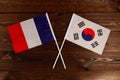 Flag of France and flag of South Korea crossed with each other. The image illustrates the relationship between countries