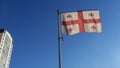 Flag of Georgia against the blue sky with sun rays and lens flare. Diplomacy concept. International relations Royalty Free Stock Photo