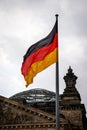 The flag of Germany flutters proudly near the German Parliament building against a cloudy sky Royalty Free Stock Photo