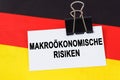 On the flag of Germany lies a business card with the inscription - macroeconomic risks