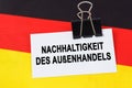 On the flag of Germany lies a business card with the inscription - sustainability of foreign trade