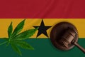 Flag of Ghana on background and justice wooden gavel with cannabis leaf. Illegal growth of cannabis plant and drugs spreading